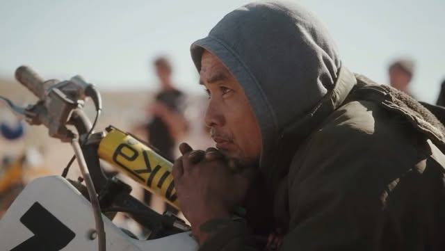Rider resting on his dirt bike in the desert